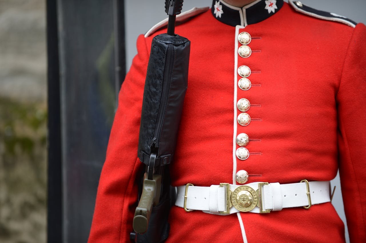 A man in a red uniform holding a gun